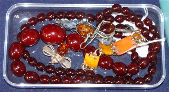 A simulated cherry amber necklace, two amber set brooches, a pair of earrings and a bracelet section?